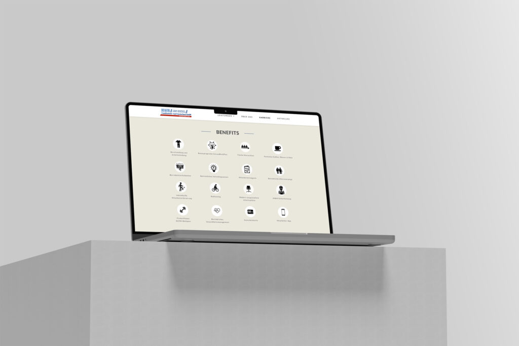 Ein Laptop auf einem weißen Sockel zeigt die Website von MWM Metalltechnik Westmünsterland mit Symbolen und Text unter einer Rubrik "Vorteile". Der Bildschirm zeigt verschiedene Symbole, die verschiedene Leistungskategorien vor einem hellen Hintergrund darstellen.
