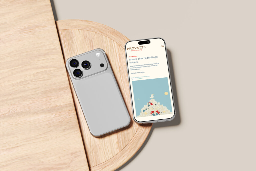Zwei moderne Smartphones liegen auf einer hellen Holzfläche; eines zeigt die PROVATIS Steuerberatung Website mit einer Berggrafik und dem Wort PROVATS, das andere zeigt seine Kameraseite.