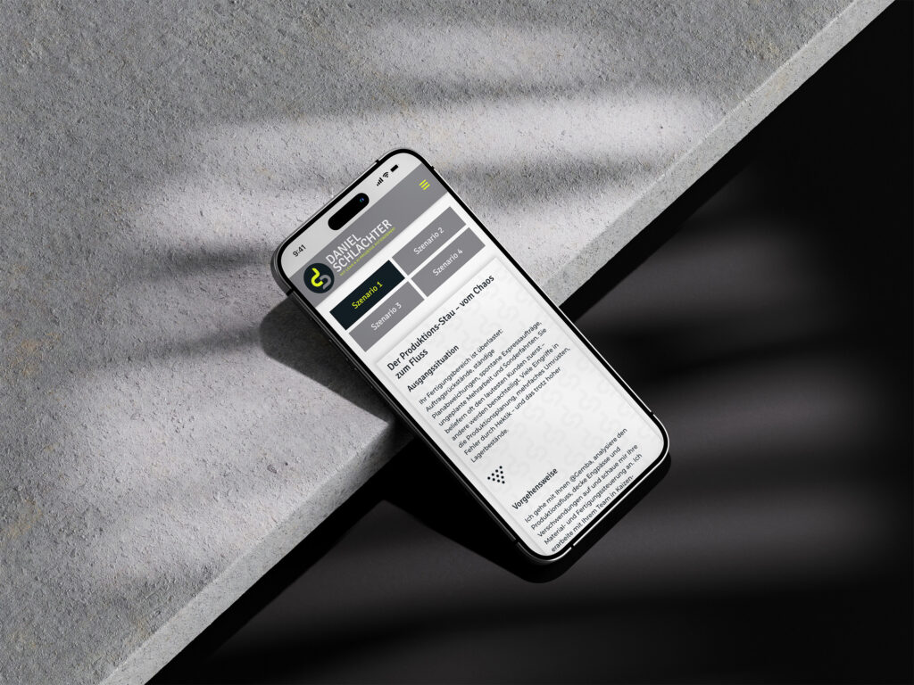 Ein Smartphone zeigt eine deutschsprachige Website mit den Rubriken SUCHEN, MERKLISTE und SUCHE SPEICHERN an, die auf einer grauen Fläche mit Schatten und diagonaler Beleuchtung ruht.