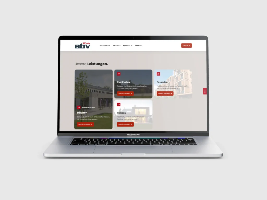 Auf einem MacBook Pro wird eine Website auf Deutsch angezeigt, auf der Dienstleistungen wie Stahlbau, Dächer, Fassaden und Holzbau mit entsprechenden Bildern vorgestellt werden. Der Bildschirm hat einen weiß-grauen Hintergrund und rote Akzente.