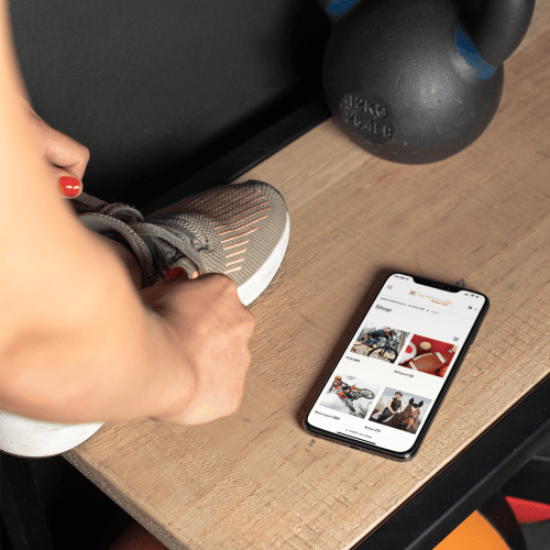 mockup-of-a-fitness-girl-tying-her-sneaker-on-a-bench-next-to-an-iphone-xs-max-25982